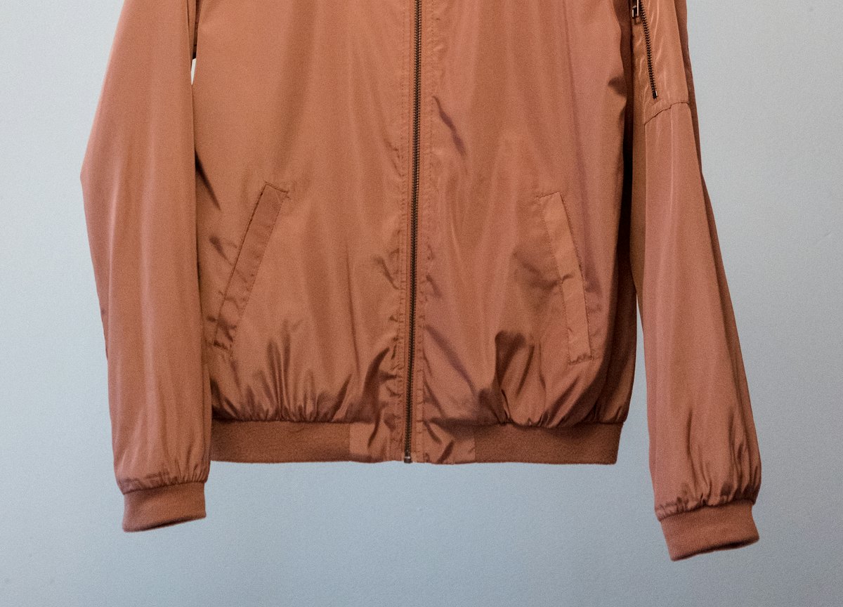 Rust bomber jacket on a hanger